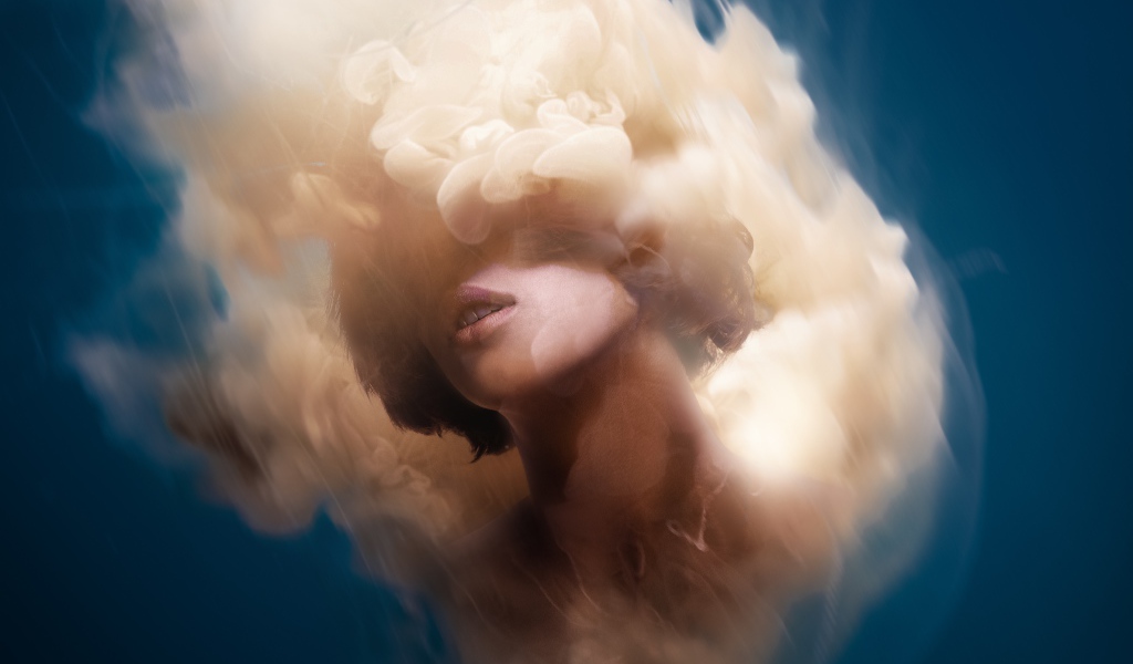 Лицо девушки в дыму на голубом фоне, иллюзия