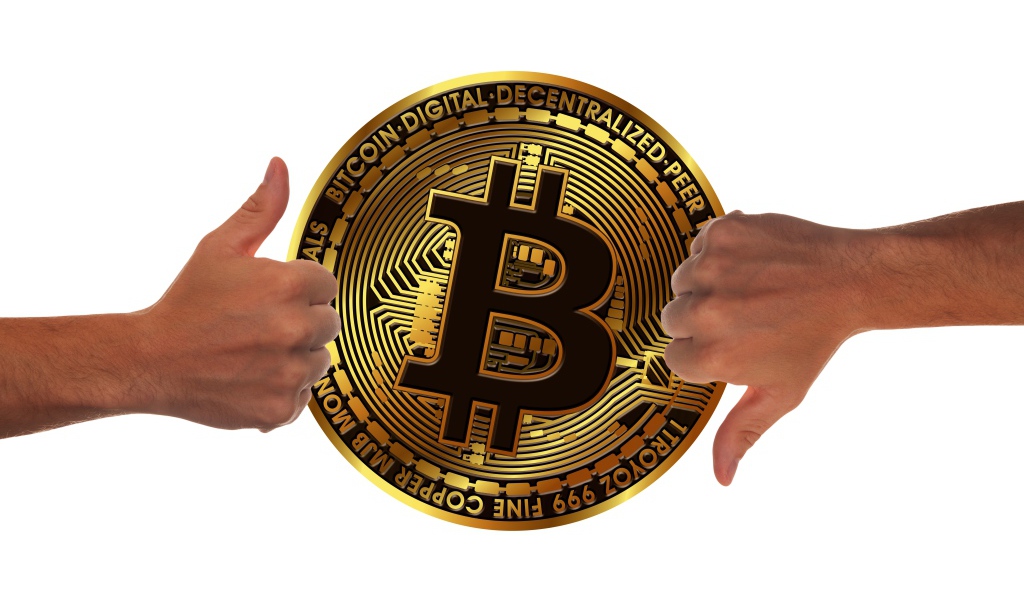 Две руки оценивают монету биткоин на белом фоне
