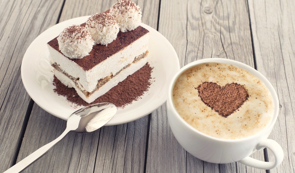 Чашка капучино с пирожным на столе 