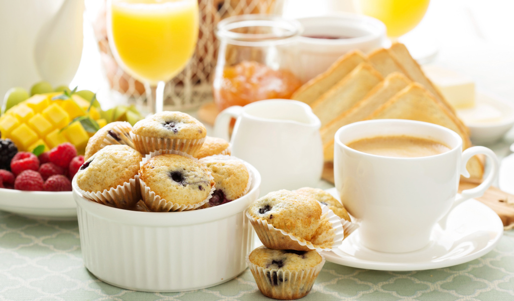 Чашка кофе с кексами на столе 