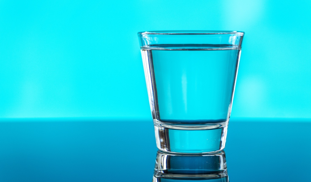 Стакан воды на голубом фоне 