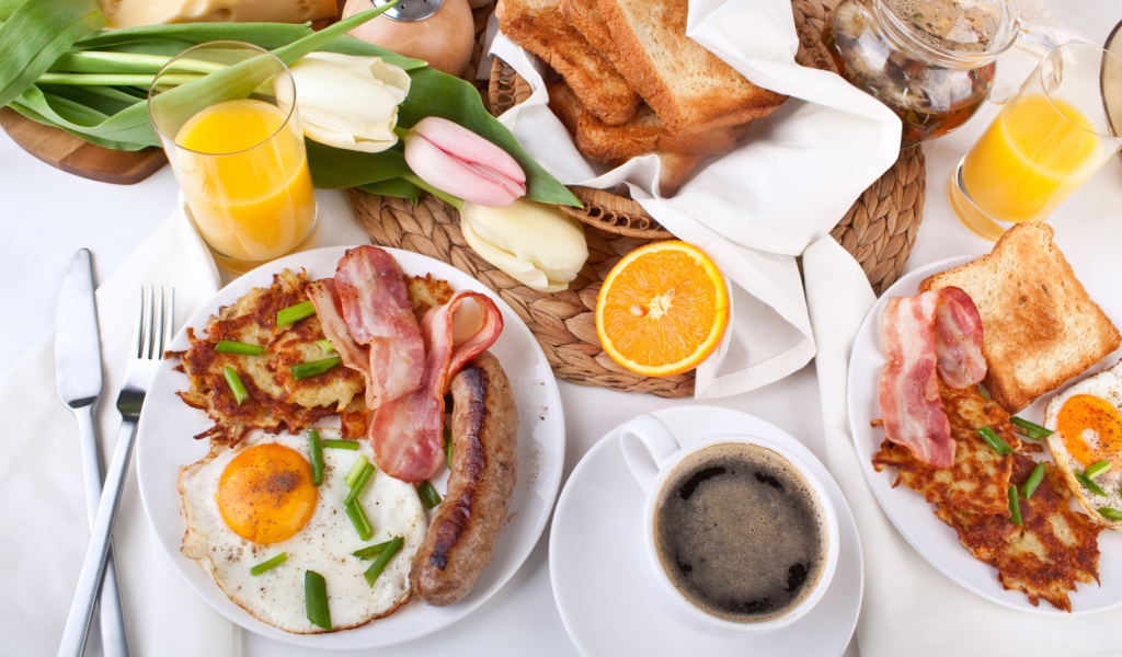 Сытный завтрак на столе с букетом тюльпанов 