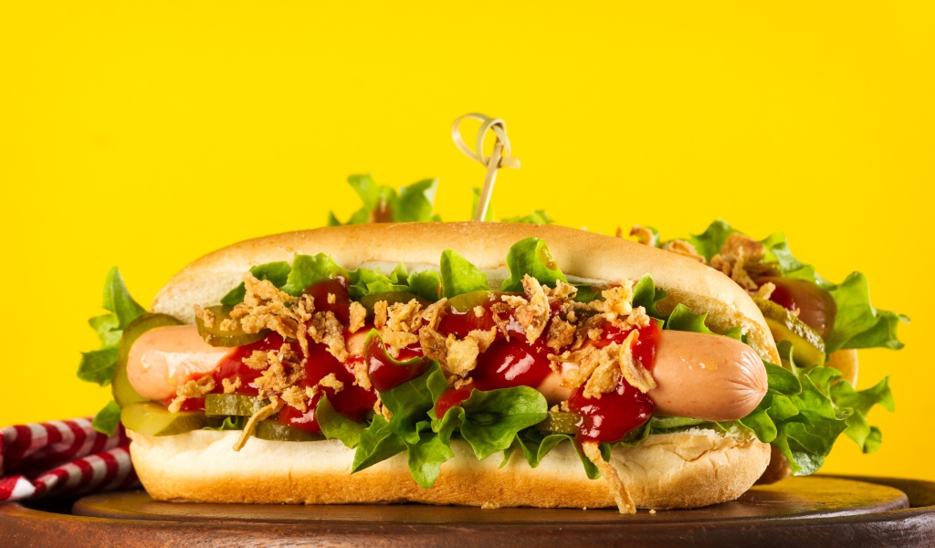 Аппетитные хотдоги на желтом фоне крупным планом