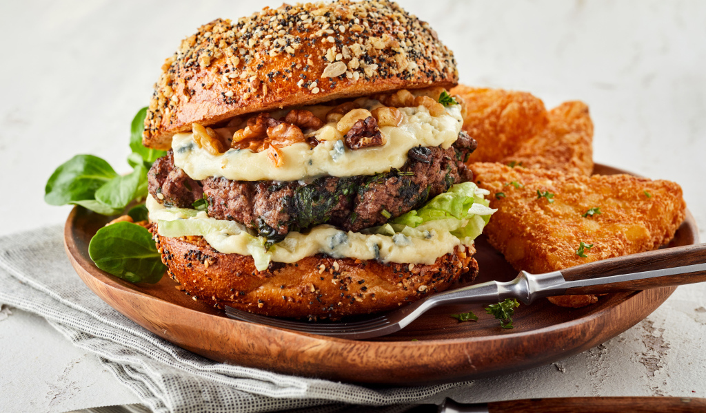 Аппетитный гамбургер на деревянной тарелке