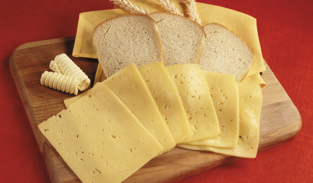 Хлеб с кусками сыра на разделочной доске