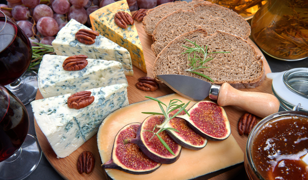 Сыр на столе с инжиром и кусками хлеба