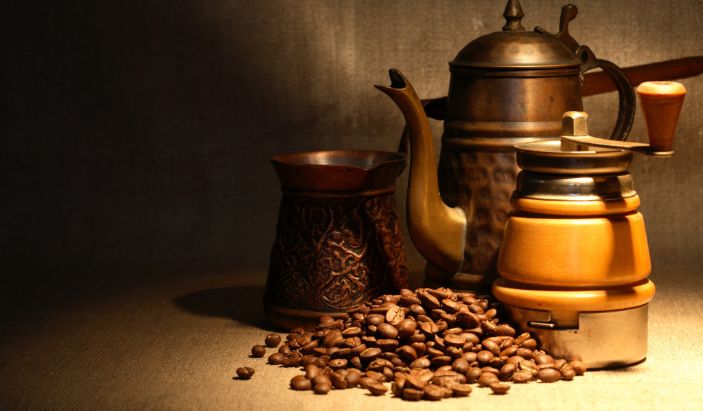 Кофемолка, турка, чайник и кофейные зерна на столе