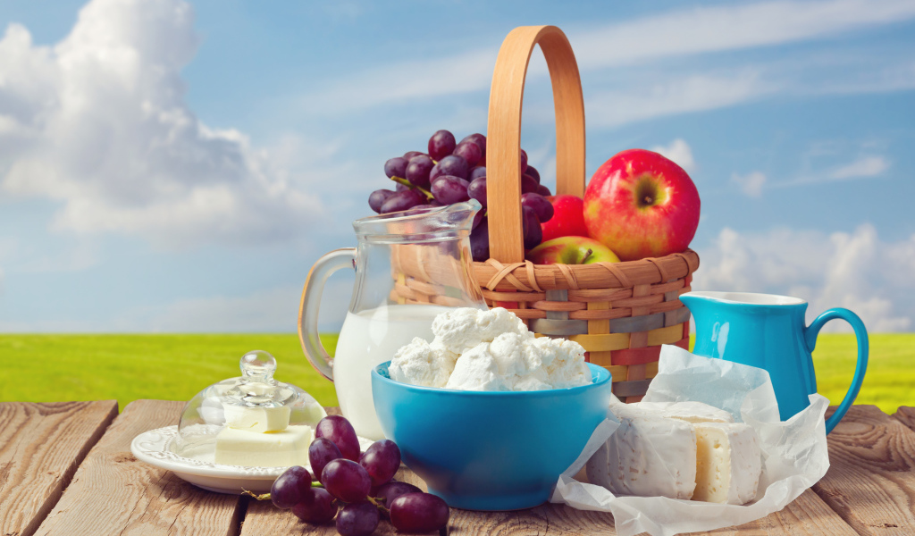 Творог с молоком на столе с виноградом и яблоками 