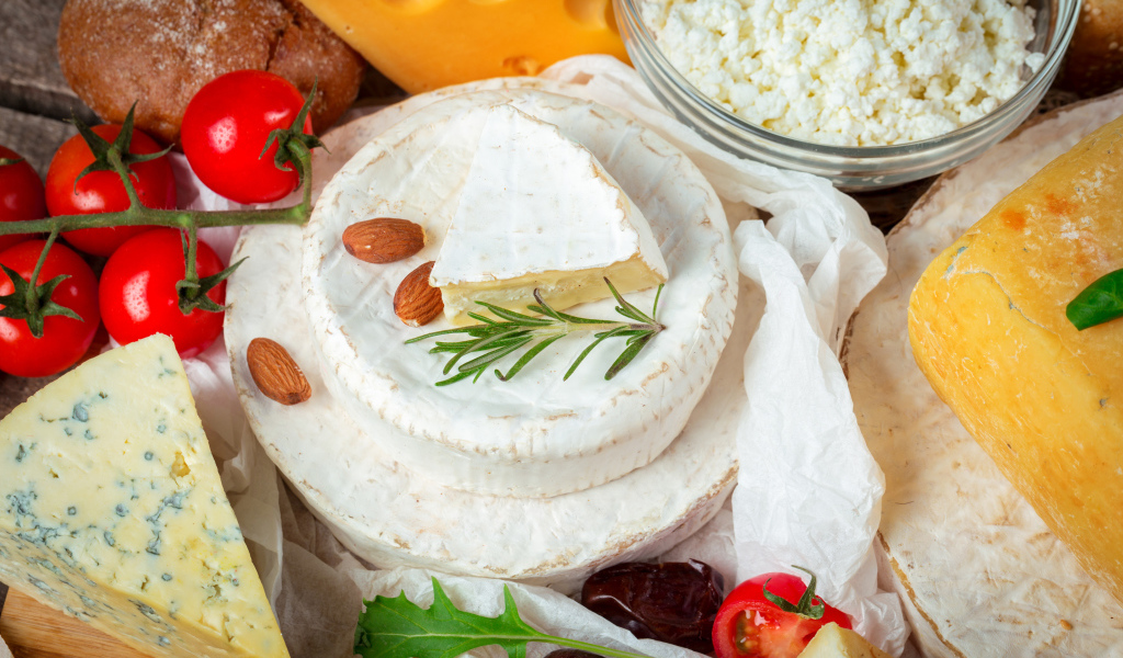 Разные виды сыра на столе с помидорами 