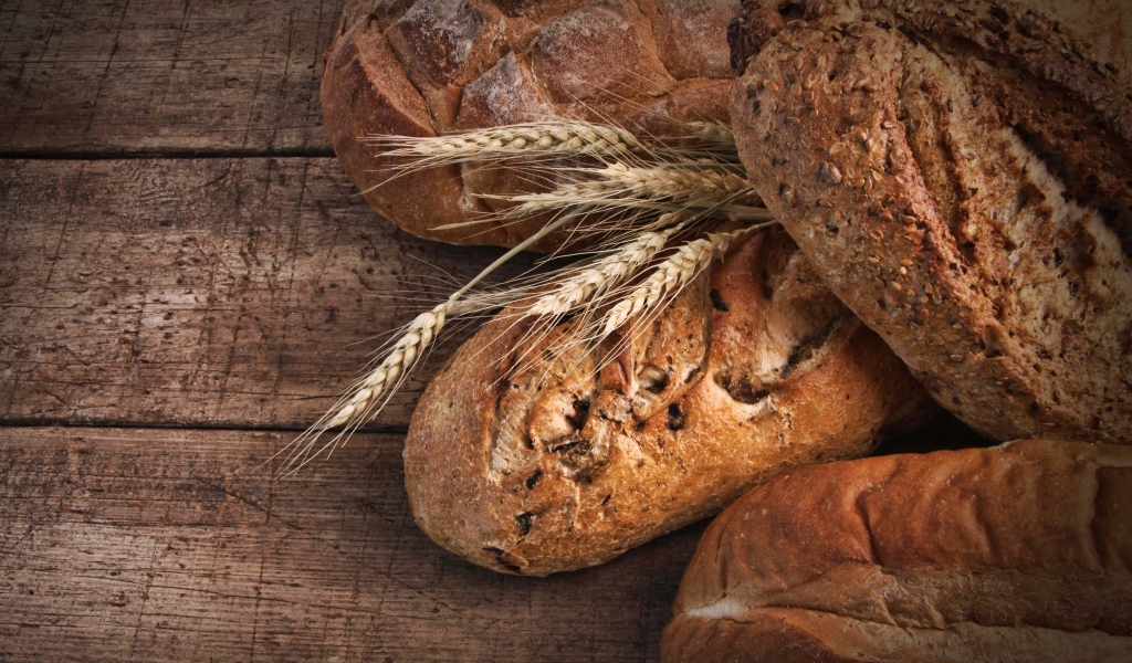 Свежий хлеб на столе с колосьями пшеницы