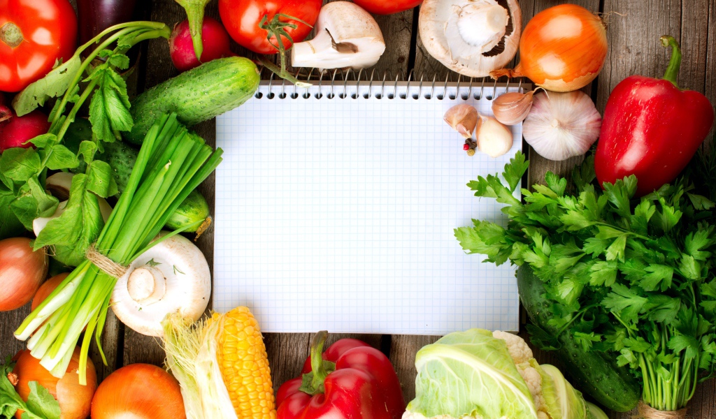 Блокнот со свежими овощами на столе 