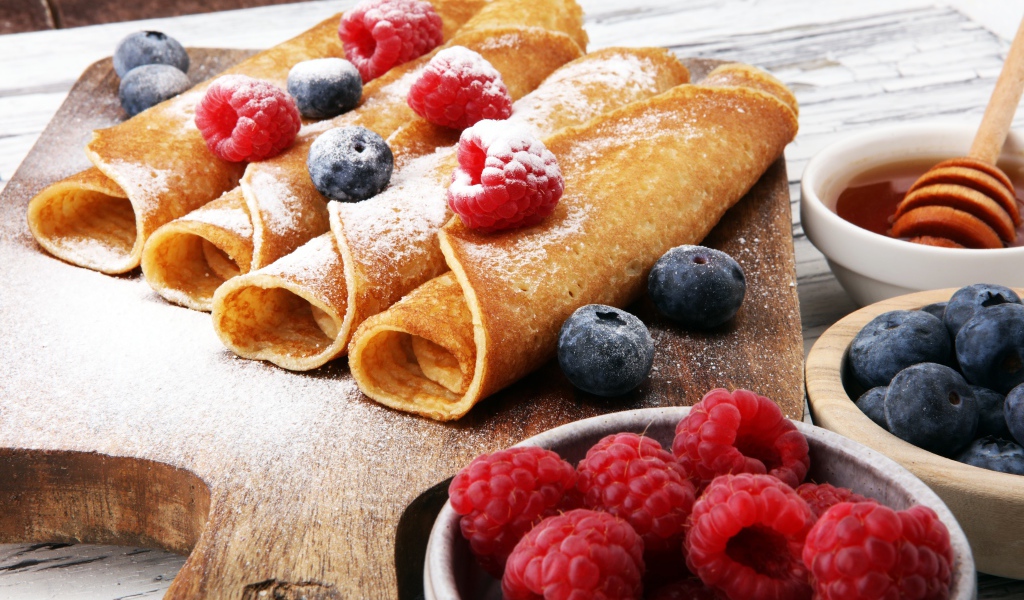 Блинчики с ягодами черники, малиной и сахарной пудрой