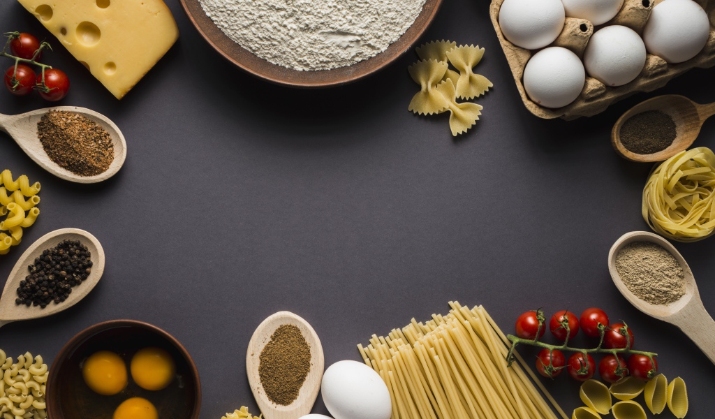 Паста, яйца, специи и помидоры на сером фоне
