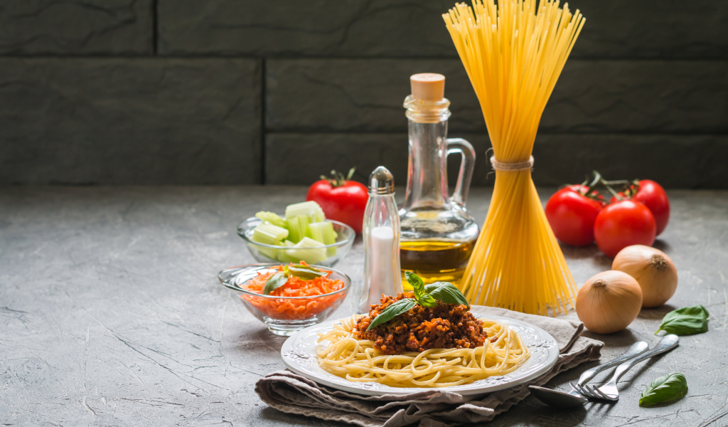 Паста с гарниром на столе с овощами и маслом