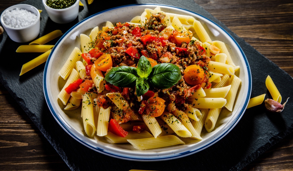 Макароны с фаршем и помидорами на столе