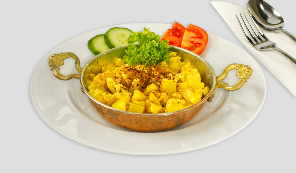 Картофель с овощами на белой тарелке