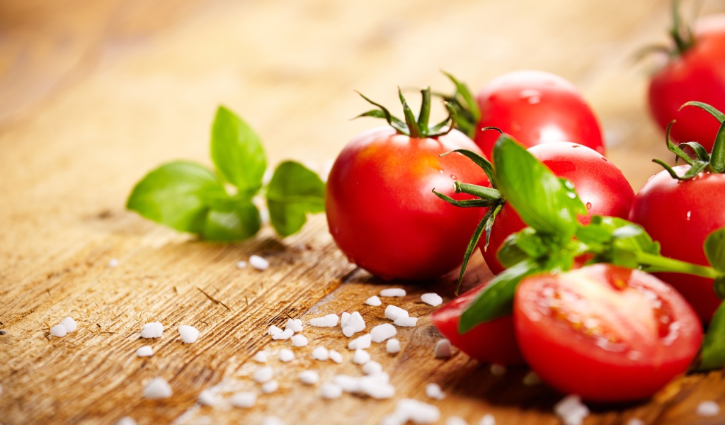 Красные помидоры с солью на столе