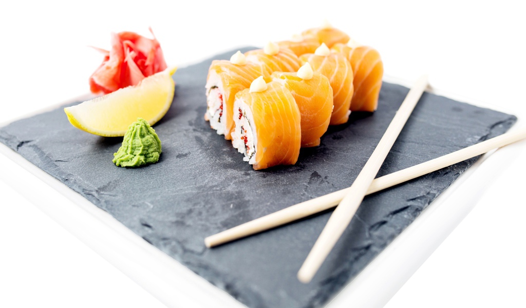 Роллы с красной рыбой на тарелке с палочками