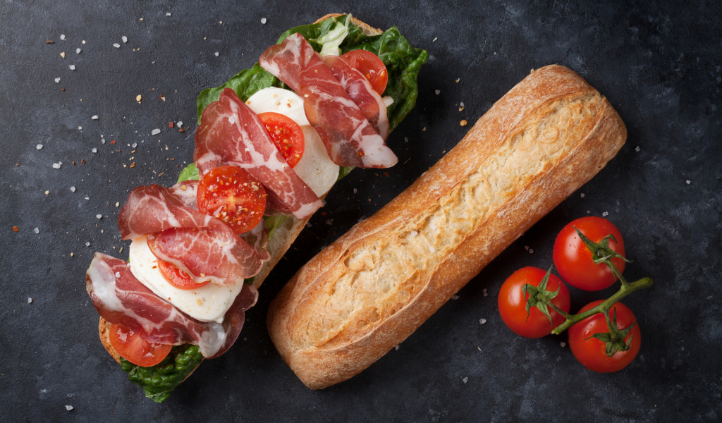 Бутерброд с ветчиной, помидорами, яйцом и листьями салата