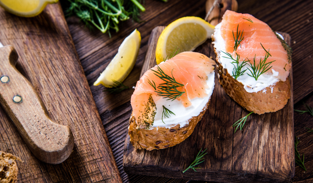 Бутерброды с сыром и красной рыбой на разделочной доске