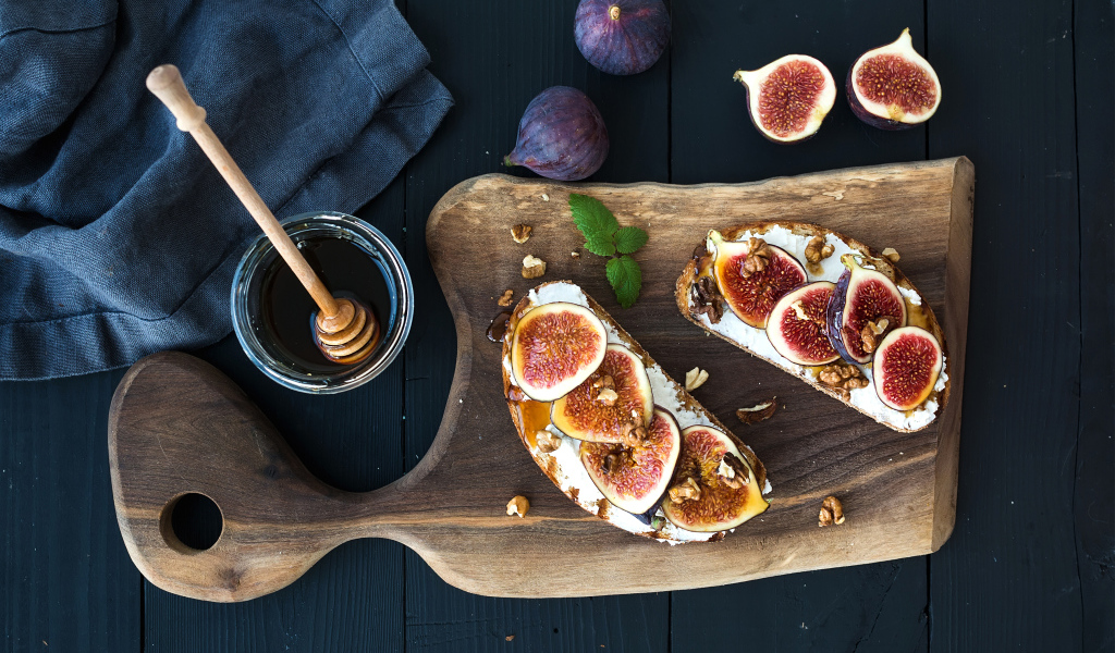 Бутерброды с инжиром на разделочной доске с медом 
