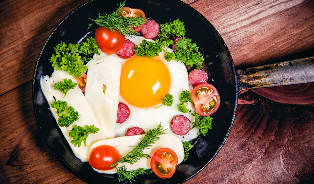 Яичница с колбасой, сыром,  помидорами и зеленью на сковороде
