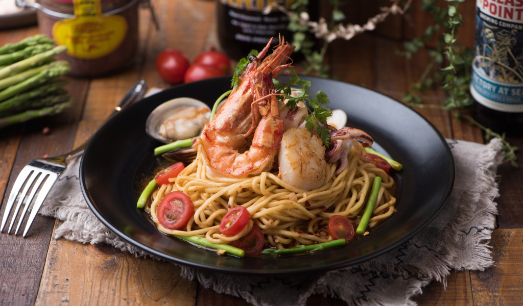 Спагетти с морепродуктами на черной тарелке
