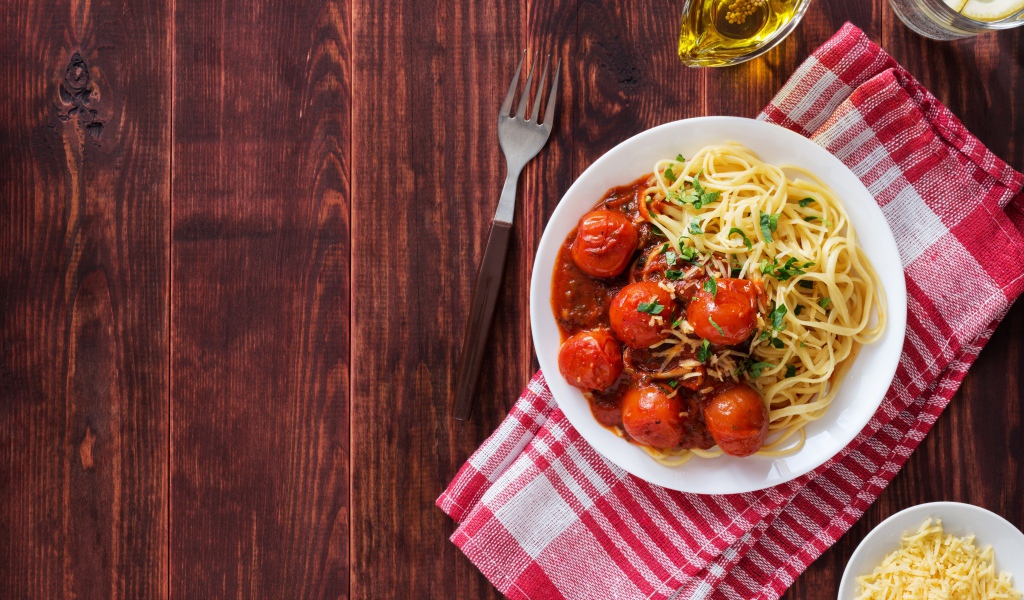Спагетти с помидорами и сыром на столе