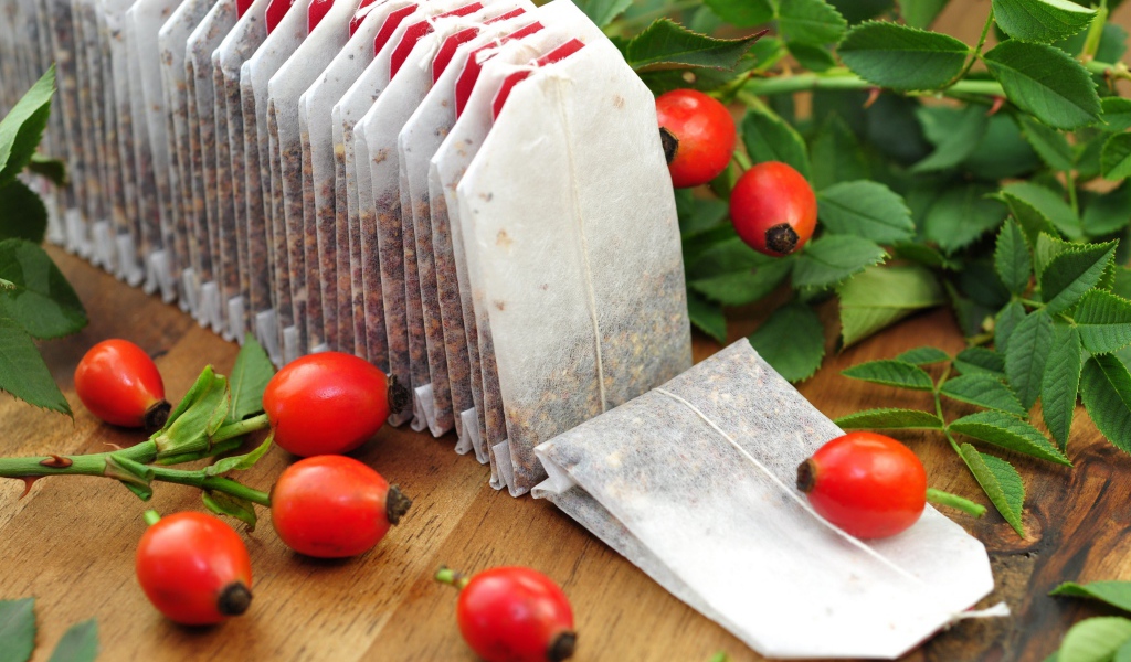 Чай в пакетиках на столе с ягодами шиповника 