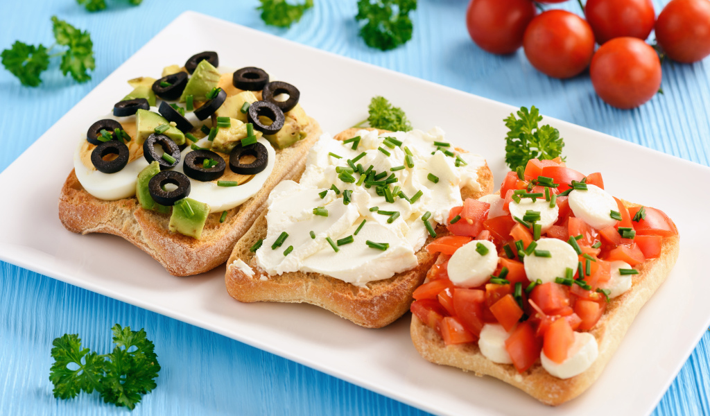 Три аппетитных бутерброда на столе с помидорами и петрушкой