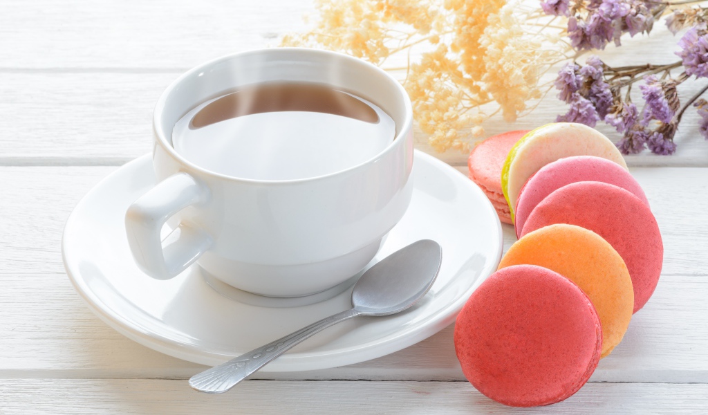 Белая чашка чая с макарунами