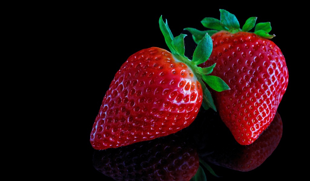 Красивая крупная красная клубника на черном  фоне