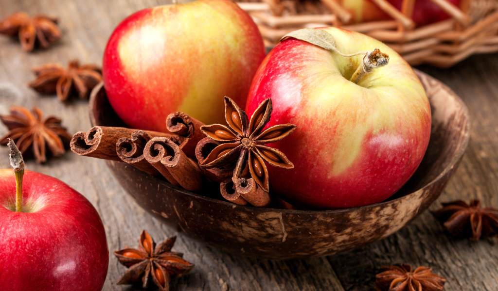 Красивые красные яблоки на столе с бадьяном и корицей