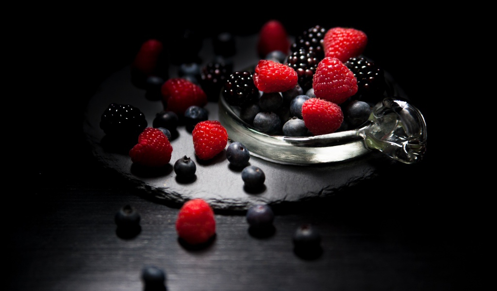 Ягоды черники, малины и ежевики на черном фоне