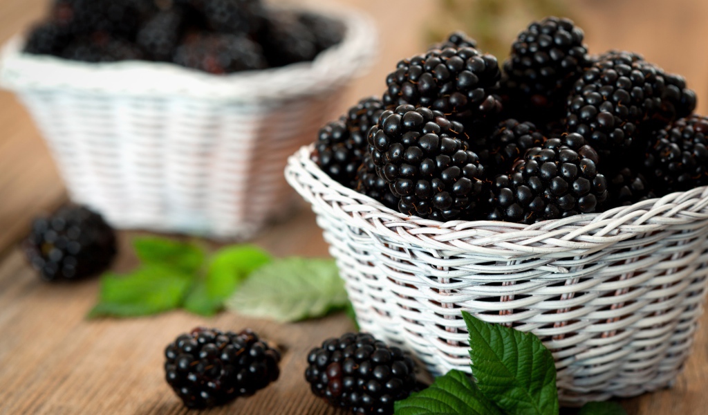 Свежые ягоды ежевики в белой корзинке на столе