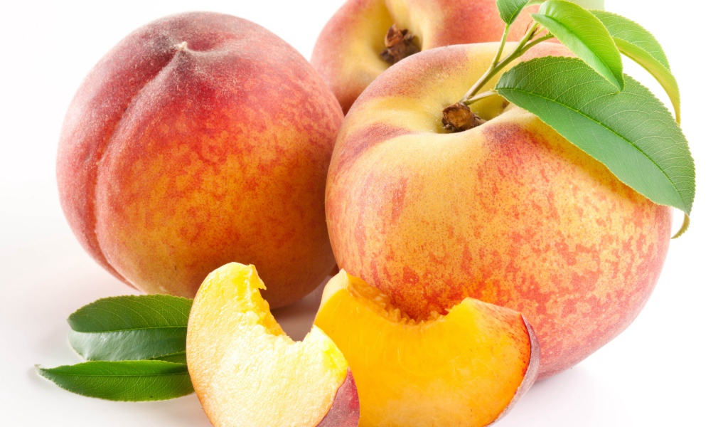 Крупные спелые сладкие персики на белом фоне