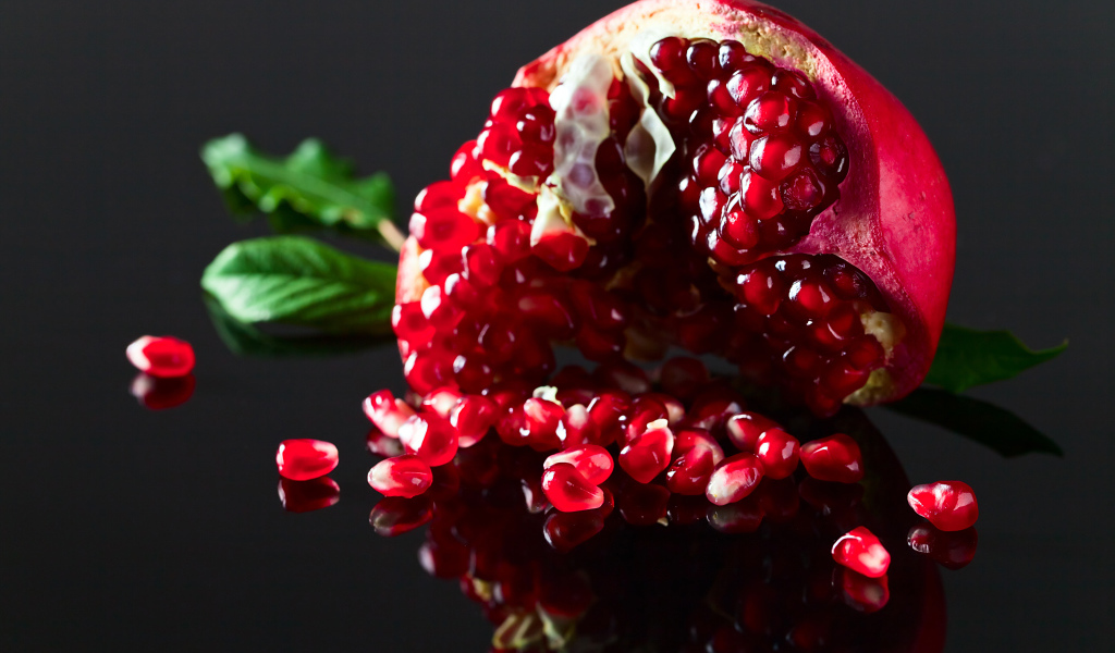 Чищенный гранат на сером фоне крупным планом