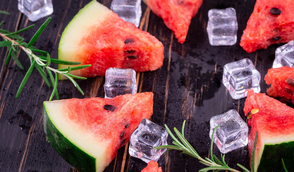 Кусочки арбуза на столе со льдом и розмарином