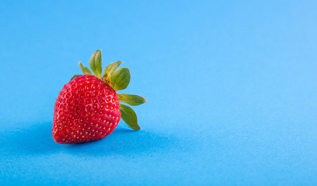 Красная спелая клубника на голубом фоне