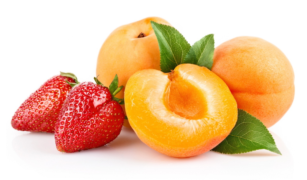 Спелые абрикосы с ягодами клубники на белом фоне