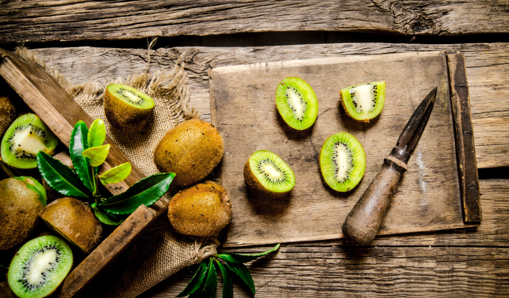 Нарезанное киви на разделочной доске с ножом