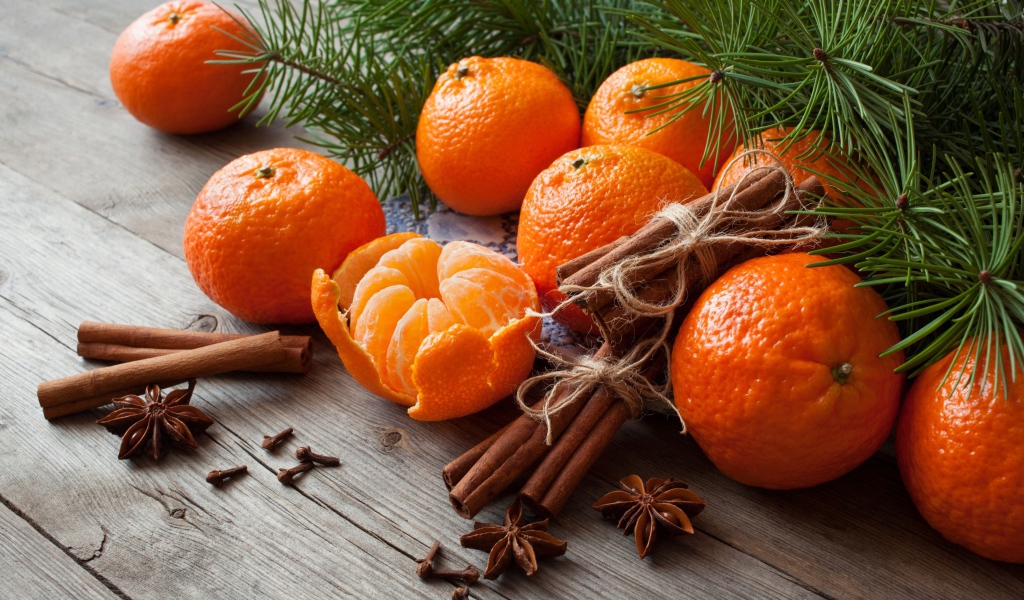 Вкусные спелые мандарины с корицей и бадьяном на столе с еловой веткой