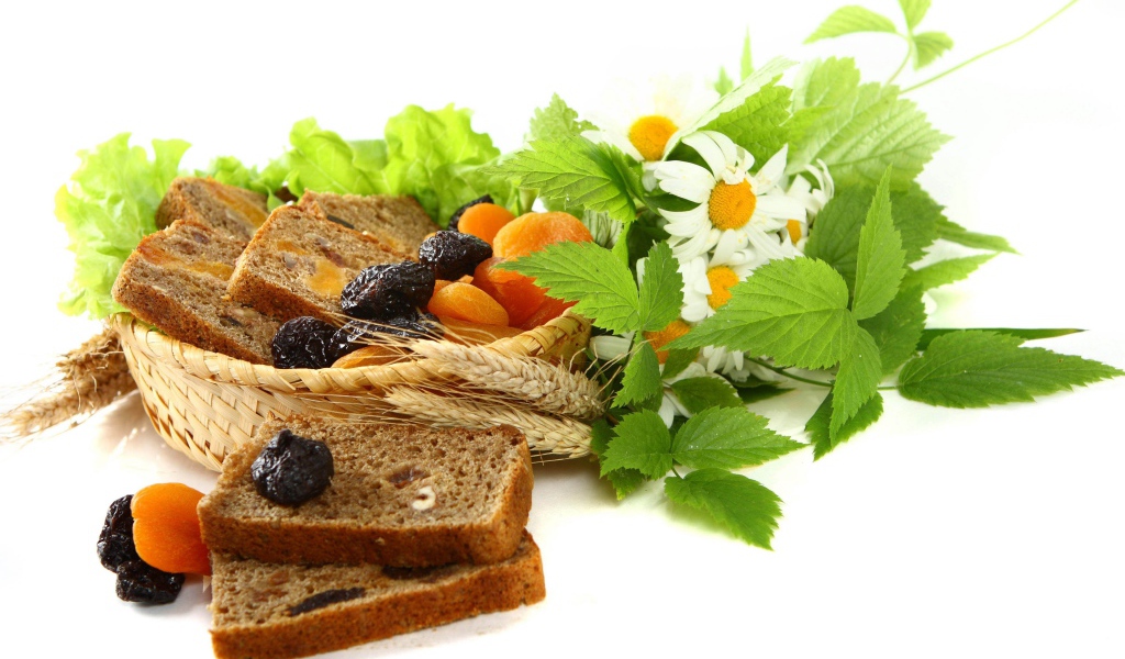 Сухофрукты с хлебом и цветами ромашки на белом фоне