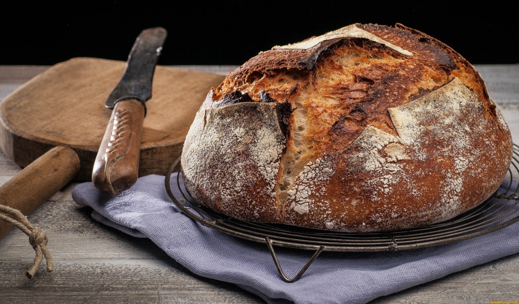 Зажареный круглый хлеб на столе с ножом