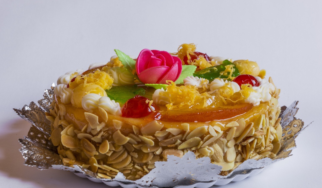 Красивый торт с кремом и ягодами украшен розовым цветком