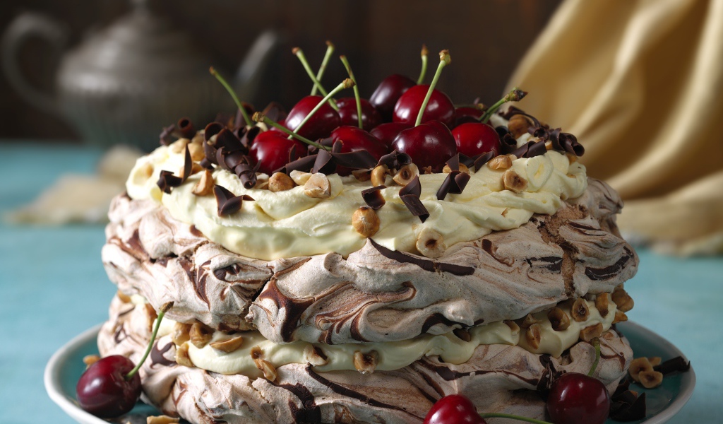 Красивый кремовый торт с шоколадом и ягодами черешни и орехами