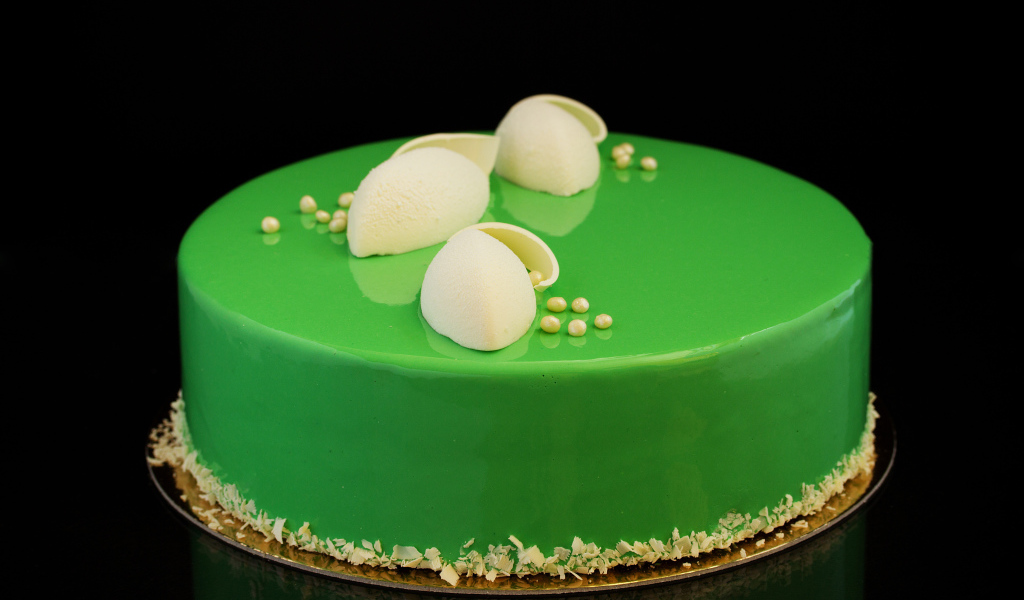Зеленый глянцевый торт отражается в черной поверхности 