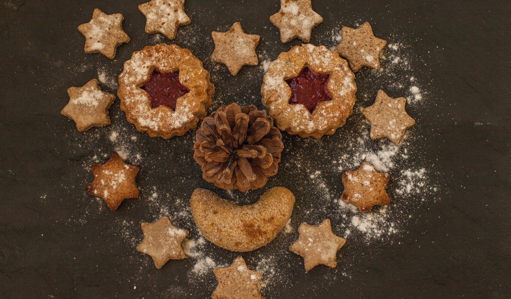Сердце с забавной рожицей выложено на столе из печенья