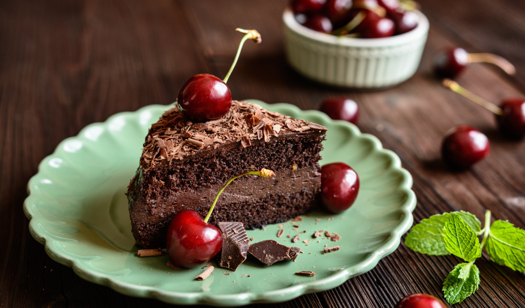 Кусок пирожного с черешнями на тарелке