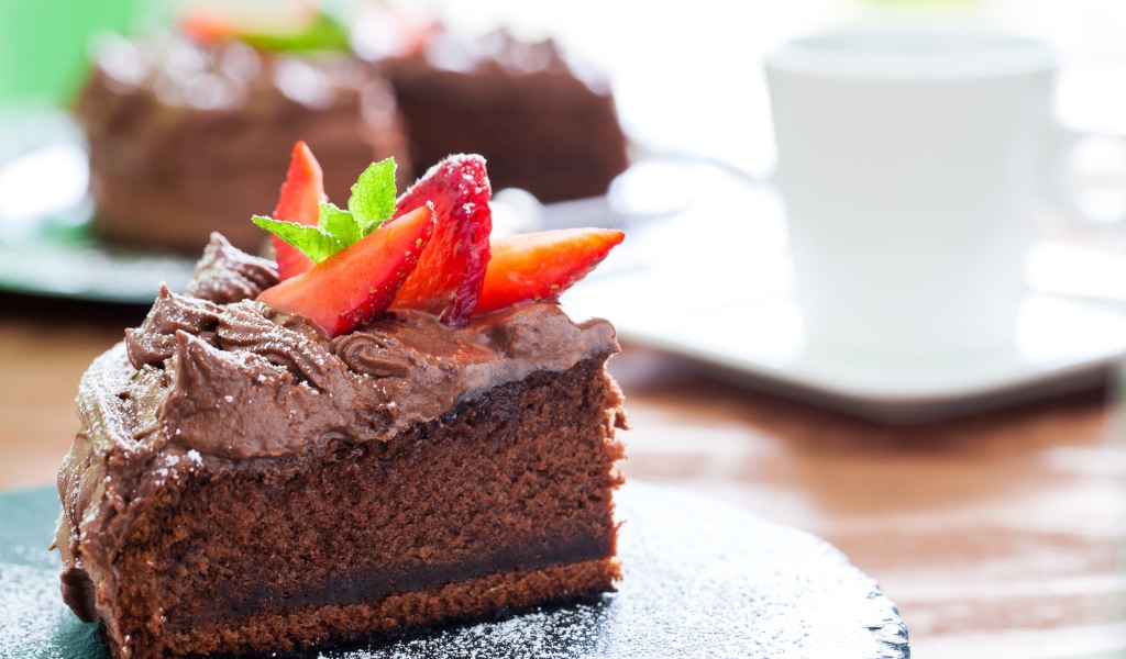 Кусок пирога с шоколадным кремом и кусочками спелой клубники 